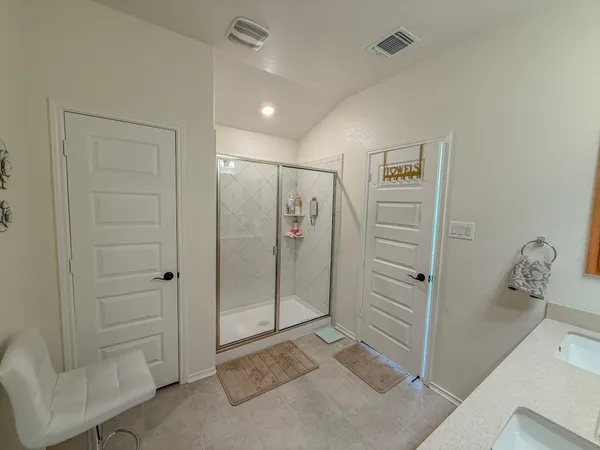 a spacious bathroom with a double vanity sink a mirror and a shower