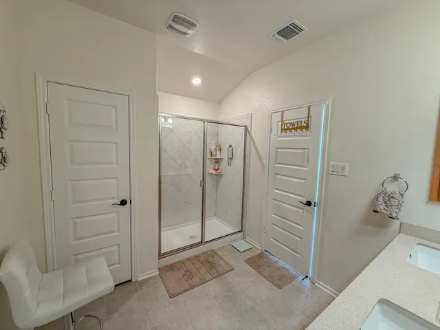 a spacious bathroom with a double vanity sink a mirror and a shower