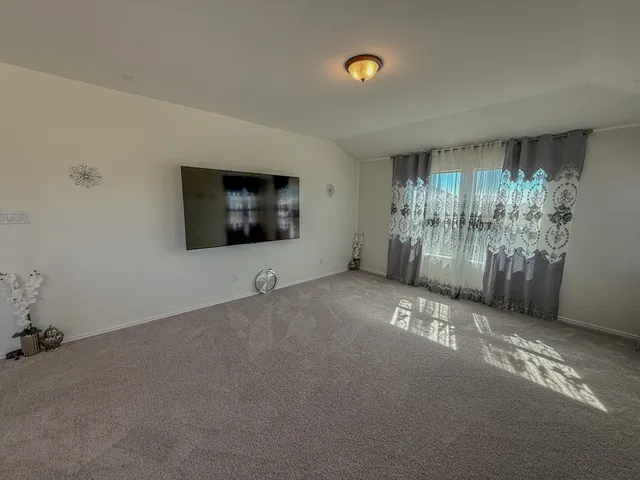 a view of a livingroom with an empty space and a window