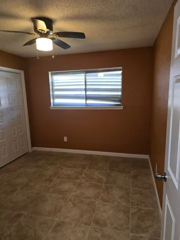 en empty room with windows and fan