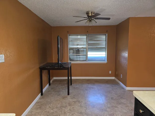 a view of room with a window and a ceiling fan