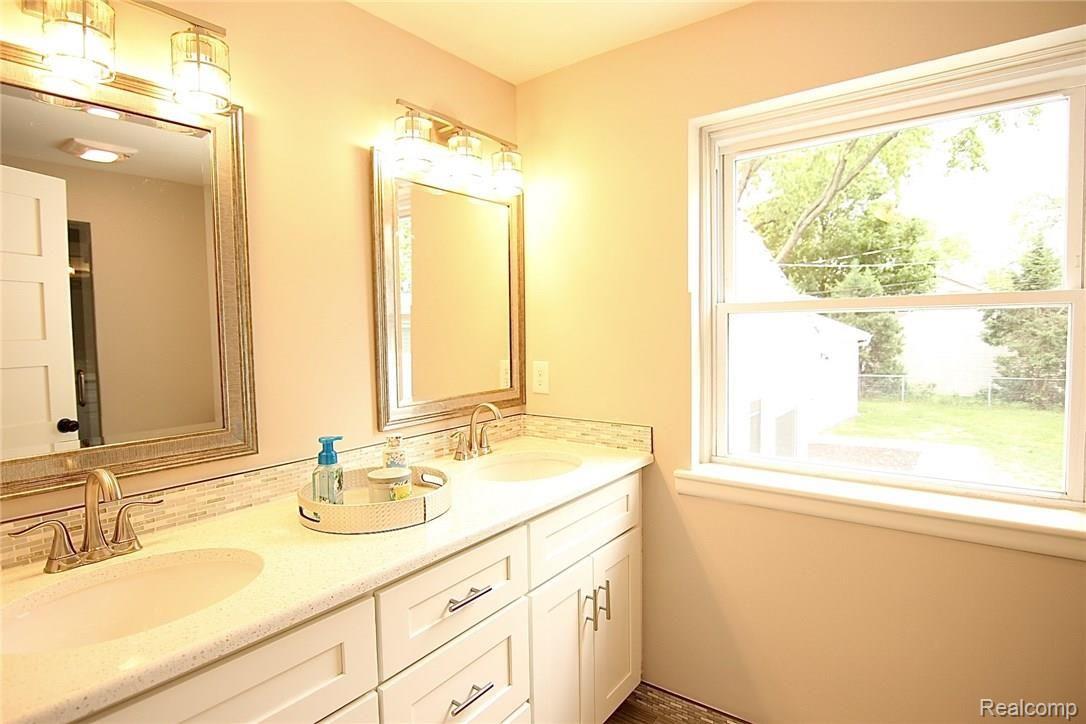 931 West 3rd Street Rochester, MI 48307 - Photo 20 of 62 Master bath with white, soft close cabinetry, dual sinks, quartz counters and window overlooking yard.