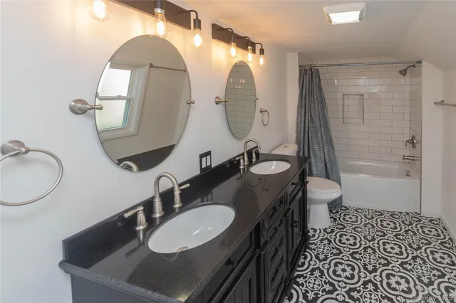 a bathroom with a double vanity sink and a mirror