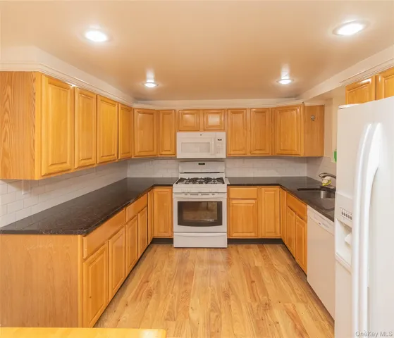 a kitchen with stainless steel appliances granite countertop a stove a sink dishwasher and a refrigerator