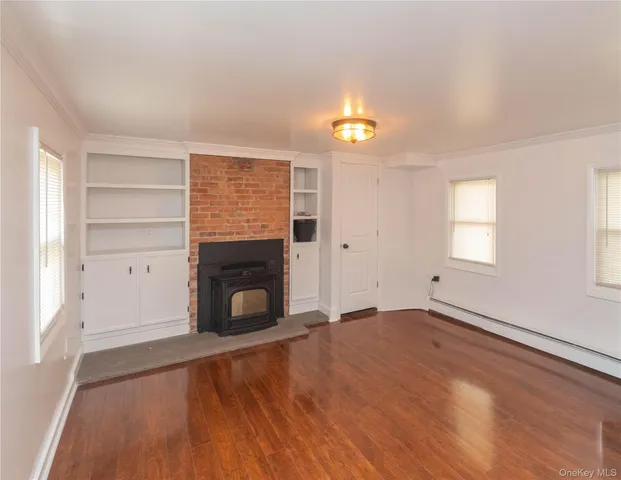 an empty room with windows and fireplace