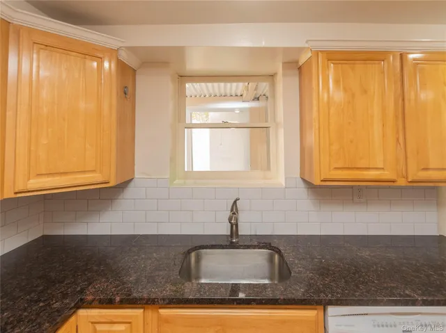 a kitchen with granite countertop a sink and cabinets