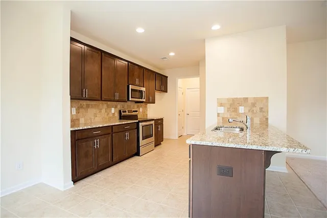 a kitchen with kitchen island a sink refrigerator and microwave