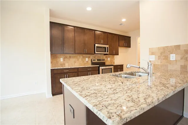 a kitchen with granite countertop stainless steel appliances and cabinets