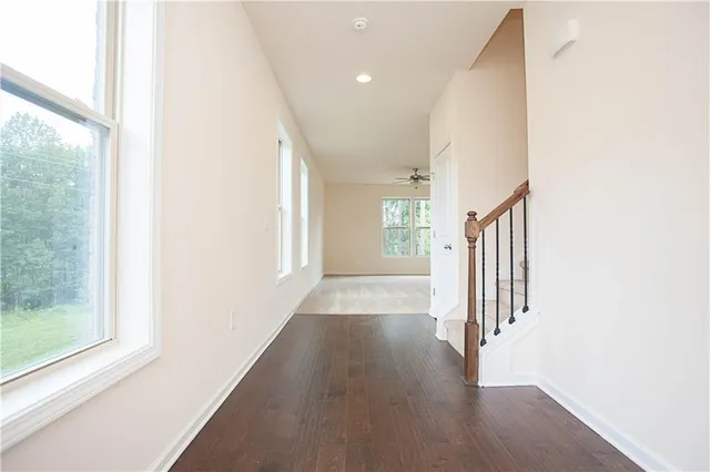 a view of a hallway with wooden floor and windows