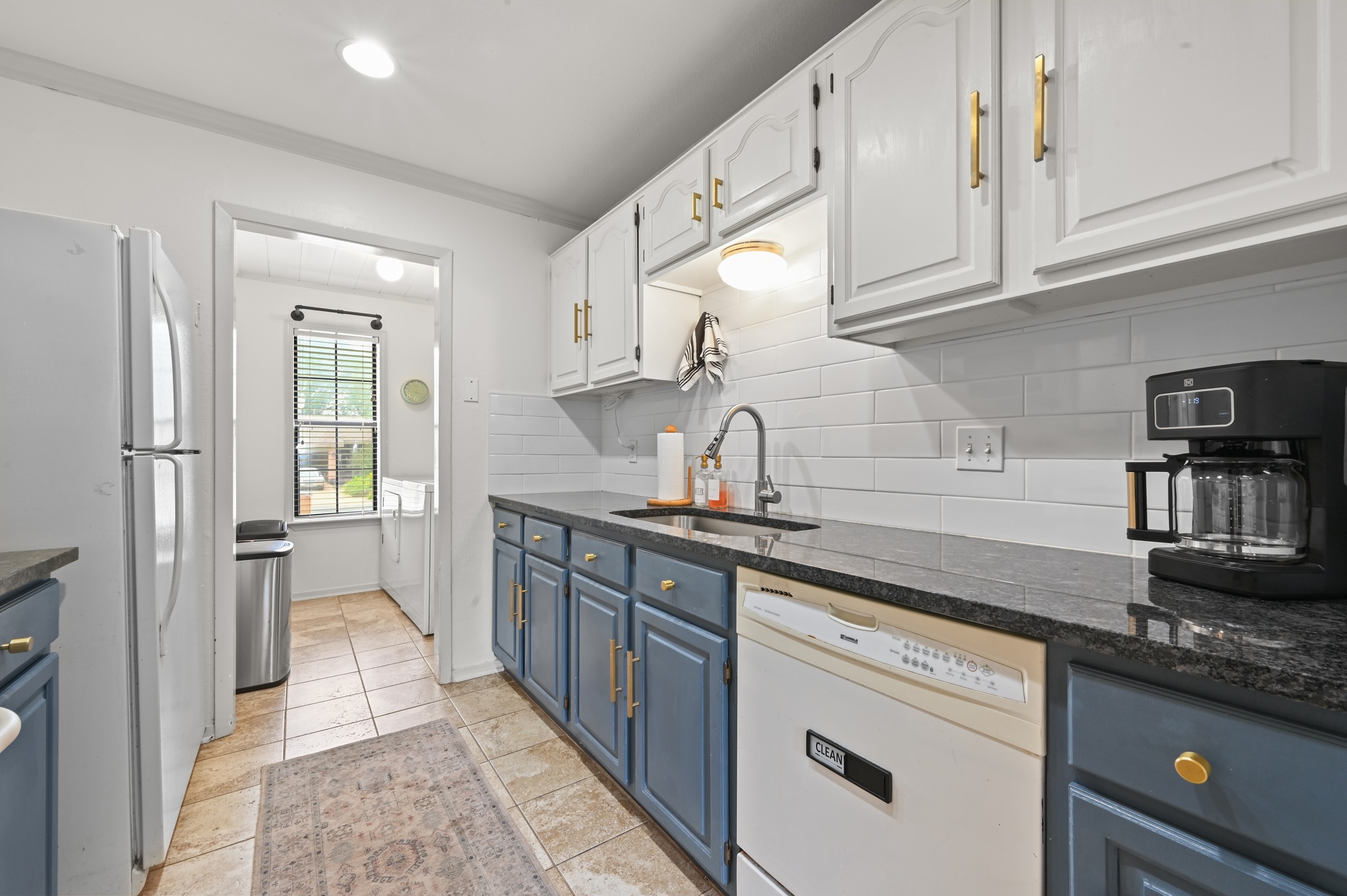 6805 Rearden Road Austin, TX 78745 - Photo 10 of 26 A well-appointed kitchen showcasing elegant two-tone cabinetry and sleek granite countertops.