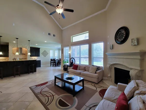 a living room with furniture a fireplace and a large window