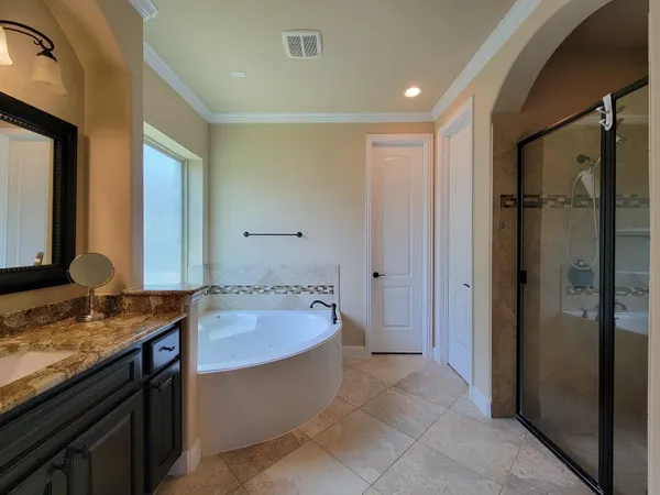 a spacious bathroom with a granite countertop tub sink and mirror