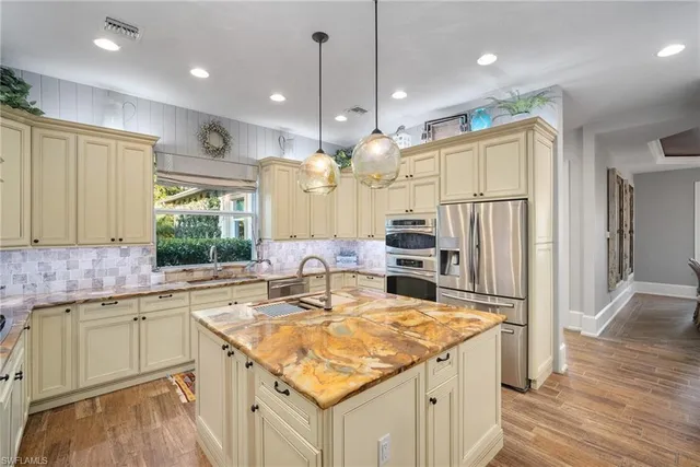 a view of a dining room and livingroom with furniture wooden floor a chandelier