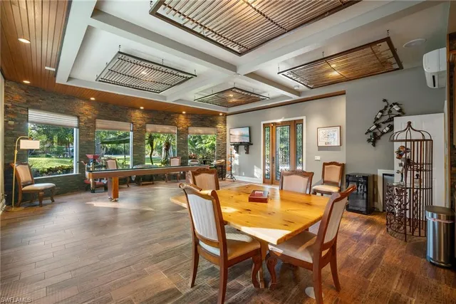 a dining room with wooden floor a glass table and chairs