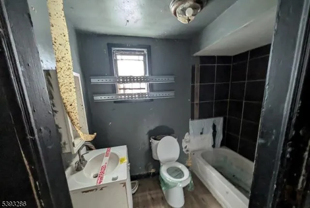 a bathroom with a granite countertop toilet sink and mirror