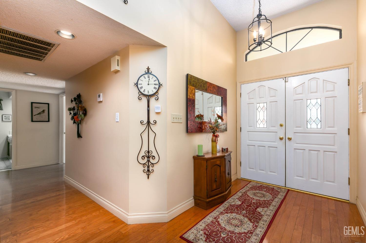 Undisclosed Address Bakersfield, CA 93312 - Photo 11 of 27 a view of a hallway with wooden floor and a chandelier