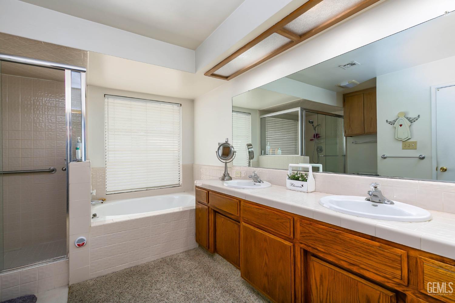 Undisclosed Address Bakersfield, CA 93312 - Photo 24 of 27 a bathroom with a tub sink and mirror