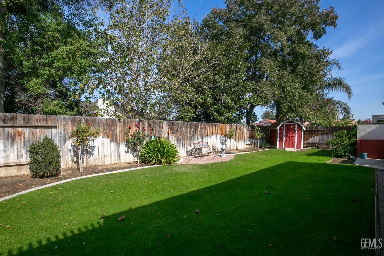Undisclosed Address Bakersfield, CA 93312 - Photo 6 of 27 a view of a yard with large trees and a barn in it
