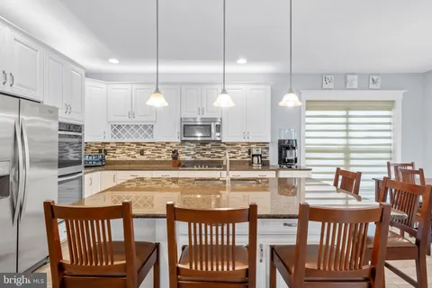 a kitchen with appliances a sink a counter top space and cabinets