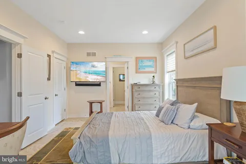 a bedroom with a bed a mirror and a large window