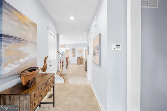 a kitchen with stainless steel appliances kitchen island granite countertop a table chairs and a refrigerator