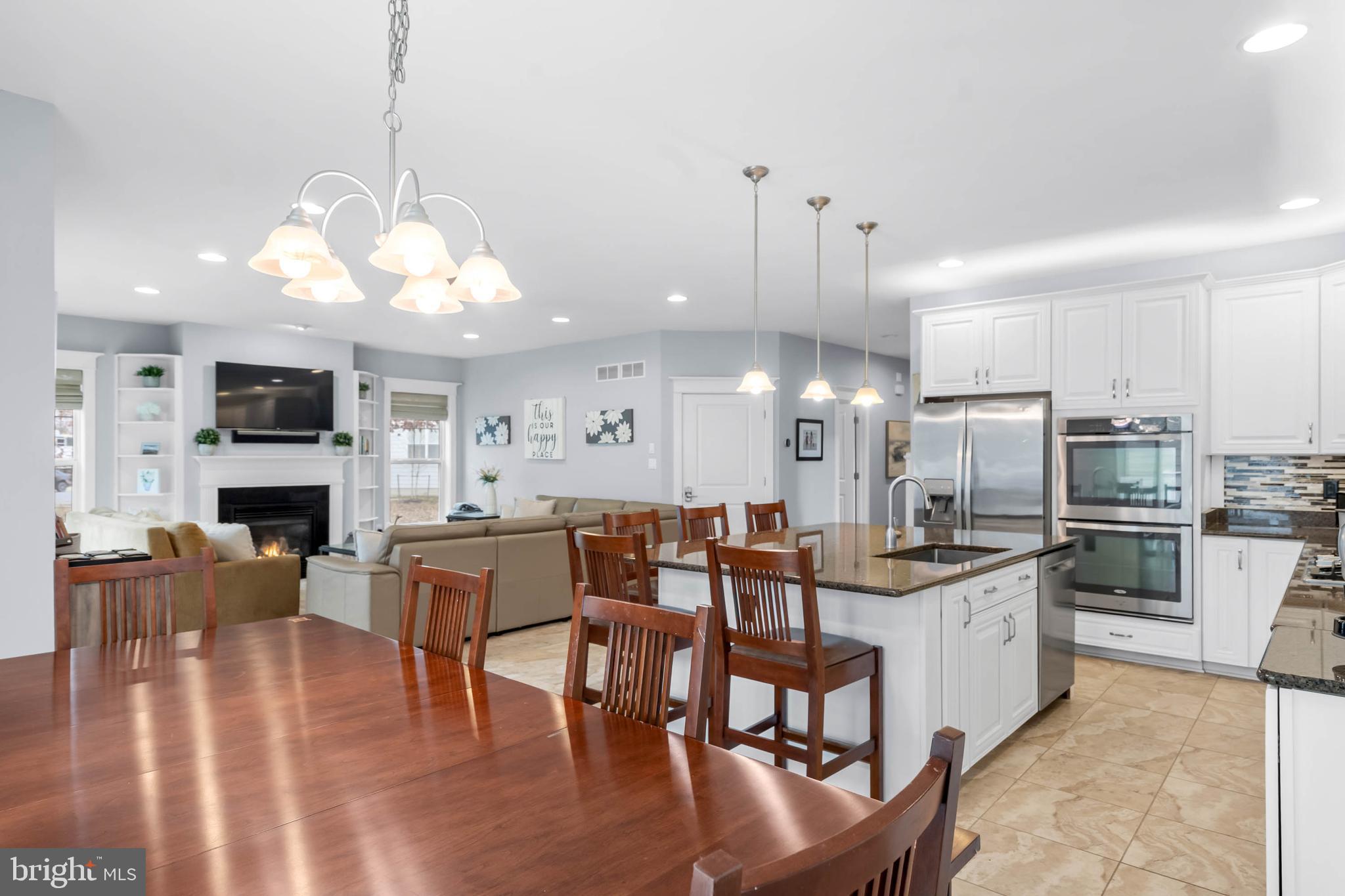 507 Jones Lane Rehoboth Beach, DE 19971 - Photo 4 of 62 a kitchen with stainless steel appliances kitchen island granite countertop a table chairs and a refrigerator