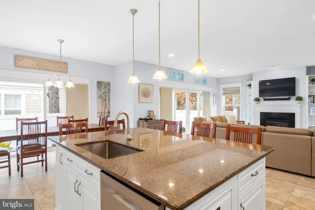 a kitchen with stainless steel appliances granite countertop a kitchen island hardwood floor and a sink
