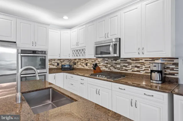 a living room with furniture kitchen and a chandelier