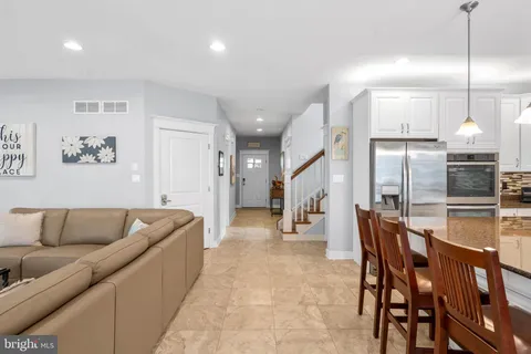 a kitchen with a dining table chairs sink and cabinets