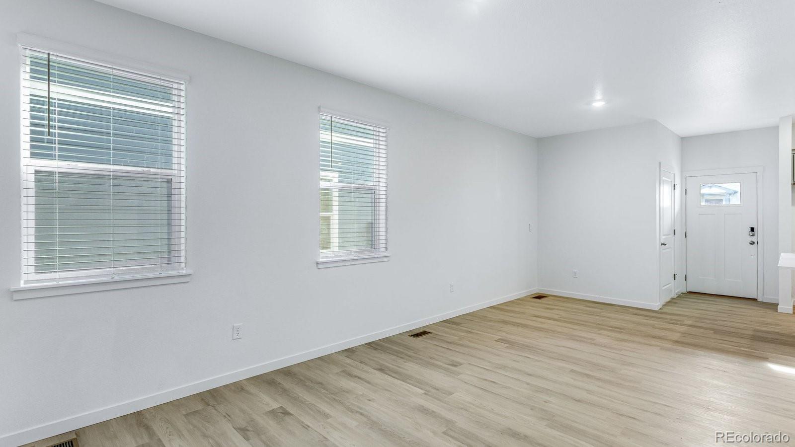 1358 South Chester Street, Unit B Denver, CO 80247 - Photo 13 of 42 a view of an empty room with wooden floor and a window