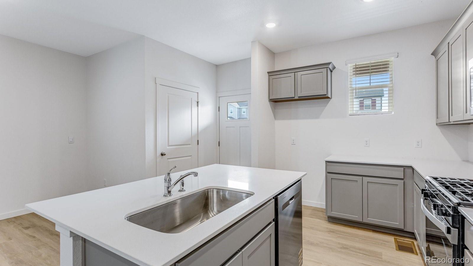 1358 South Chester Street, Unit B Denver, CO 80247 - Photo 20 of 42 a kitchen with a sink and a stove top oven with wooden floor