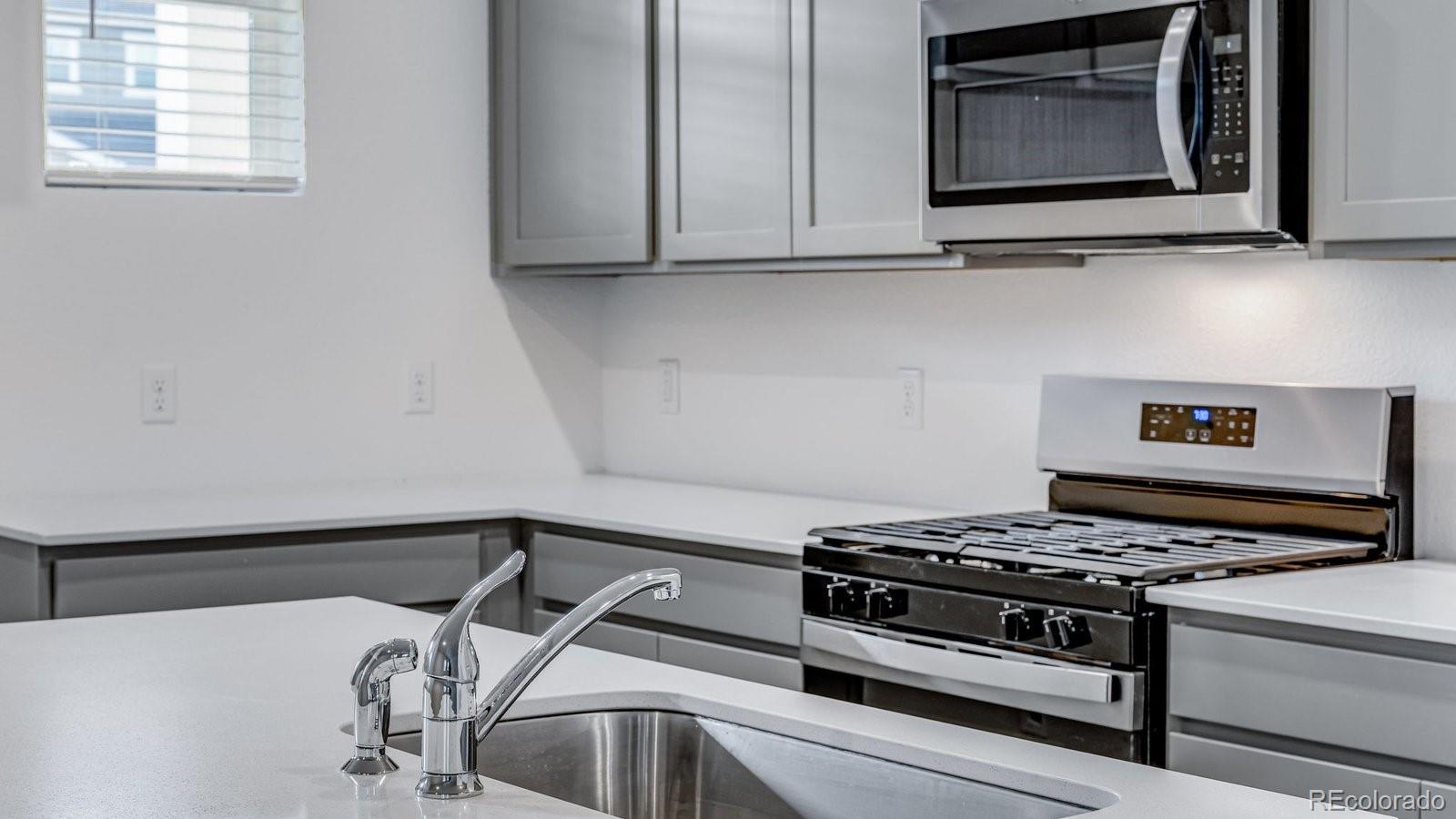 1358 South Chester Street, Unit B Denver, CO 80247 - Photo 23 of 42 a stove top oven sitting inside of a kitchen