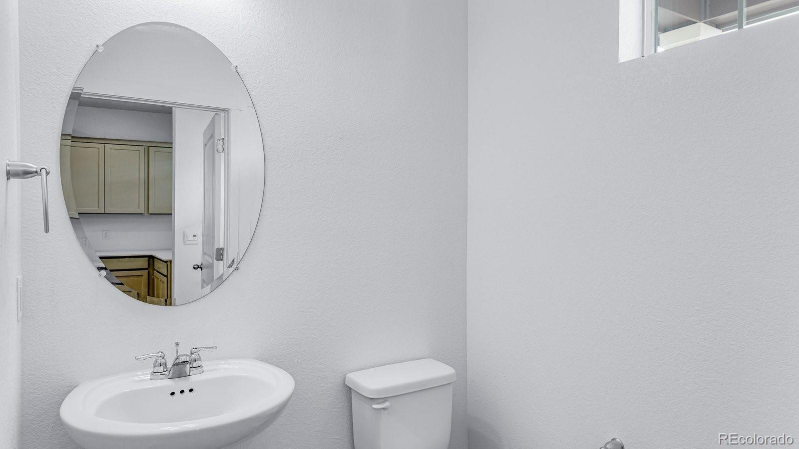 1358 South Chester Street, Unit B Denver, CO 80247 - Photo 25 of 42 a bathroom with a toilet a sink and mirror