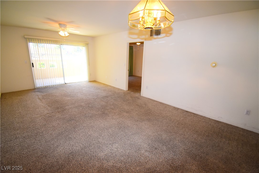 1901 Villa Palms Court, Unit 101 Las Vegas, NV 89128 - Photo 8 of 19 Spare room featuring a chandelier, carpet flooring, and ceiling fan