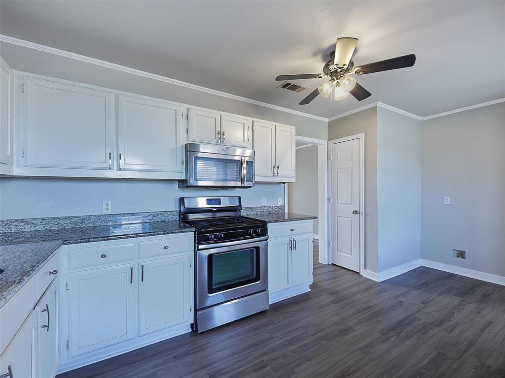 707 Doris Lane Gunter, TX 75058 - Photo 11 of 25 a kitchen with stainless steel appliances granite countertop a stove a sink and white cabinets