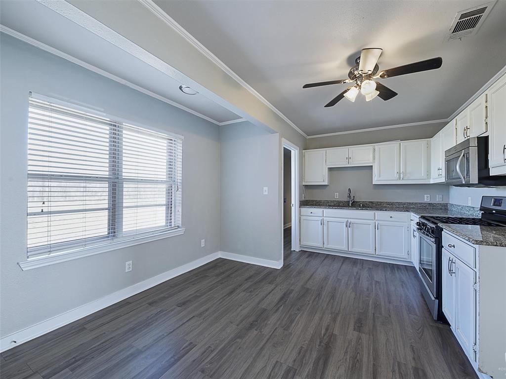 707 Doris Lane Gunter, TX 75058 - Photo 8 of 25 a kitchen with a refrigerator and white cabinets