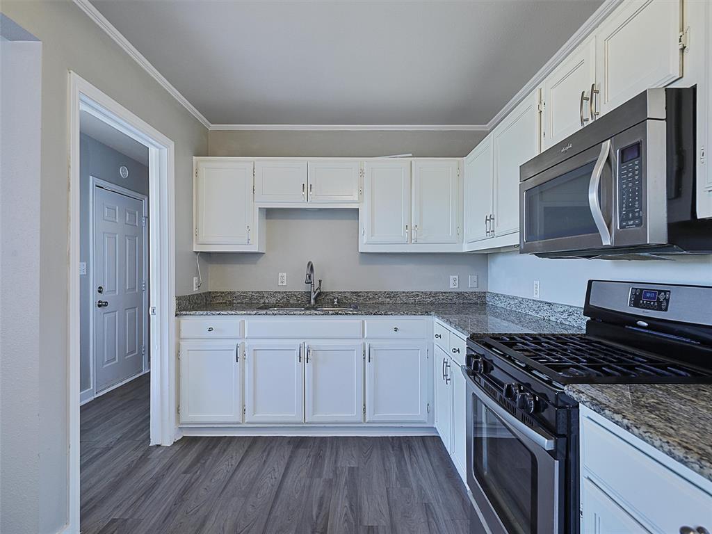 707 Doris Lane Gunter, TX 75058 - Photo 10 of 25 a kitchen with granite countertop cabinets stainless steel appliances and a wooden floor
