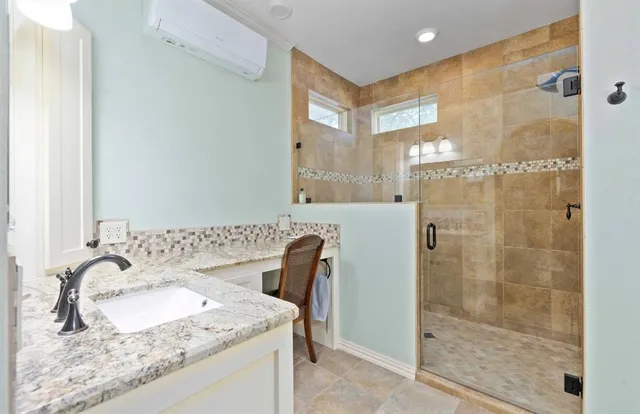 a bathroom with a granite countertop sink a mirror and a shower