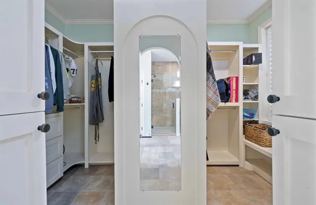a view of walk in closet with clothes and shoes