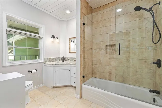 a bathroom with a granite countertop sink a toilet and bathtub