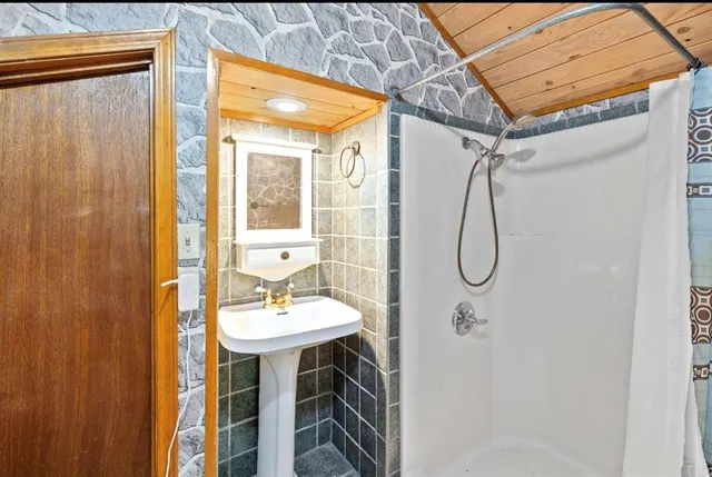 a bathroom with a sink a mirror and shower