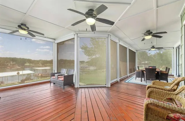 a living room with furniture floor to ceiling window and wooden floor