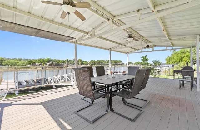 a view of a roof deck with table and chairs barbeque with wooden floor