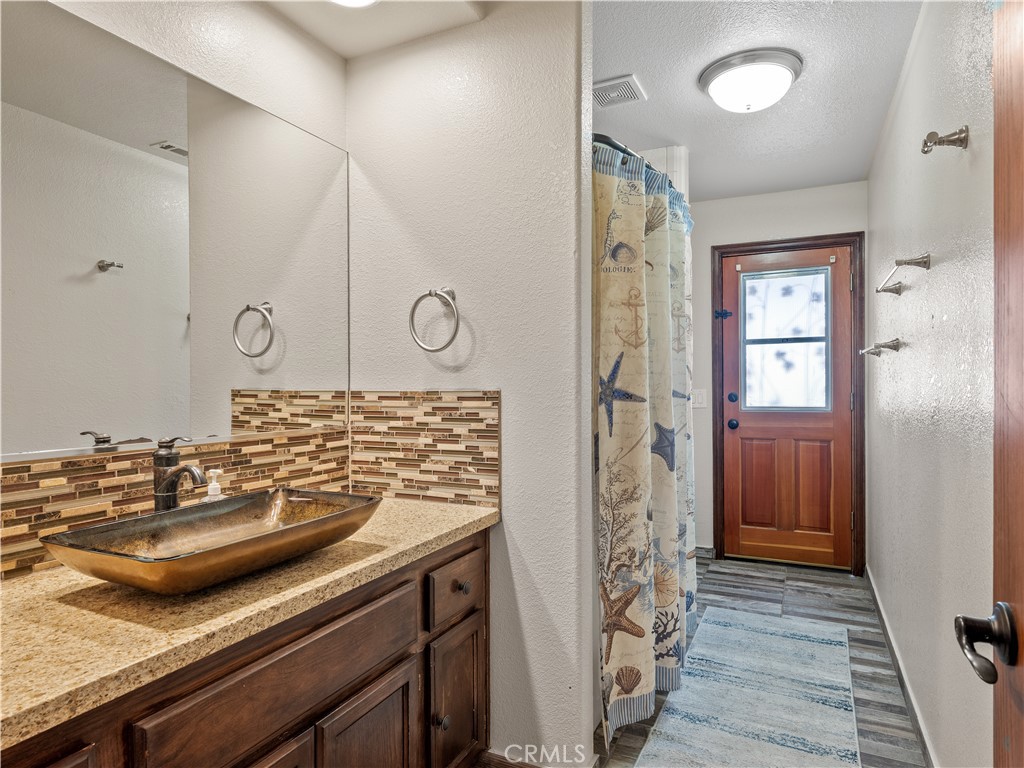 13991 Jicarilla Road Apple Valley, CA 92307 - Photo 22 of 44 a bathroom with a granite countertop sink a mirror and shower