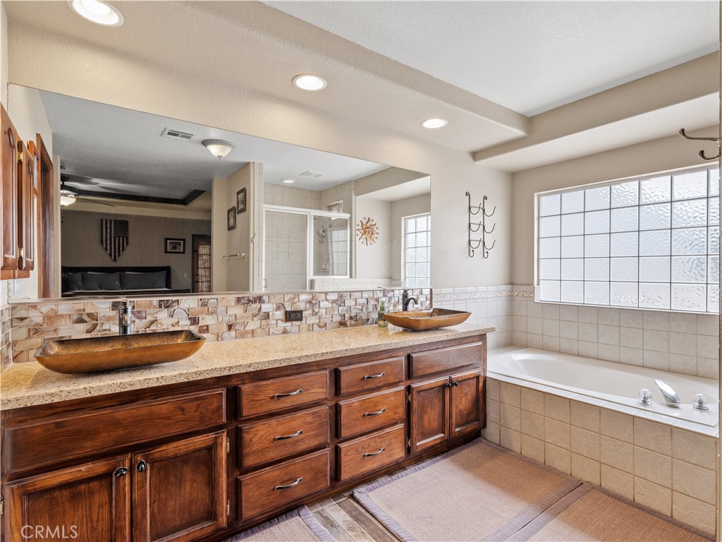 13991 Jicarilla Road Apple Valley, CA 92307 - Photo 27 of 44 a bathroom with a tub double sink window and mirror
