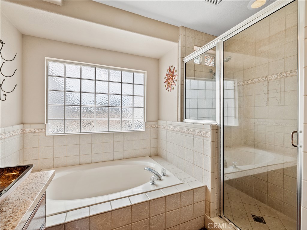 13991 Jicarilla Road Apple Valley, CA 92307 - Photo 28 of 44 a bathroom with a bathtub and window