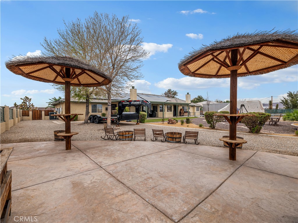 13991 Jicarilla Road Apple Valley, CA 92307 - Photo 39 of 44 a view of a swimming pool with a table and chairs under an umbrella