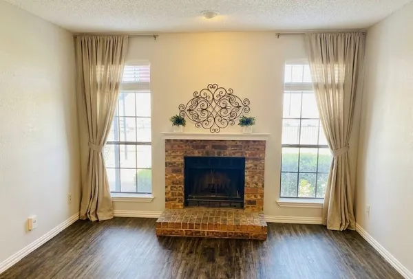 a living room with a fireplace and windows