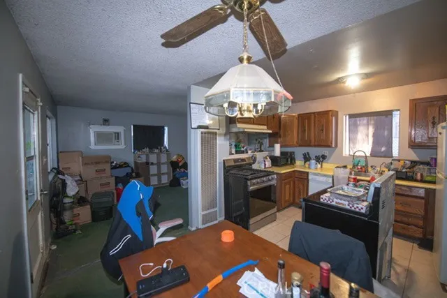 a kitchen with a refrigerator a stove top oven a sink dishwasher a dining table and chairs with wooden floor