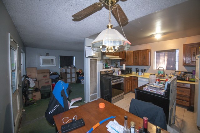 6701 Gaylord Street Riverside, CA 92505 - Photo 24 of 25 a kitchen with a refrigerator a stove top oven a sink dishwasher a dining table and chairs with wooden floor